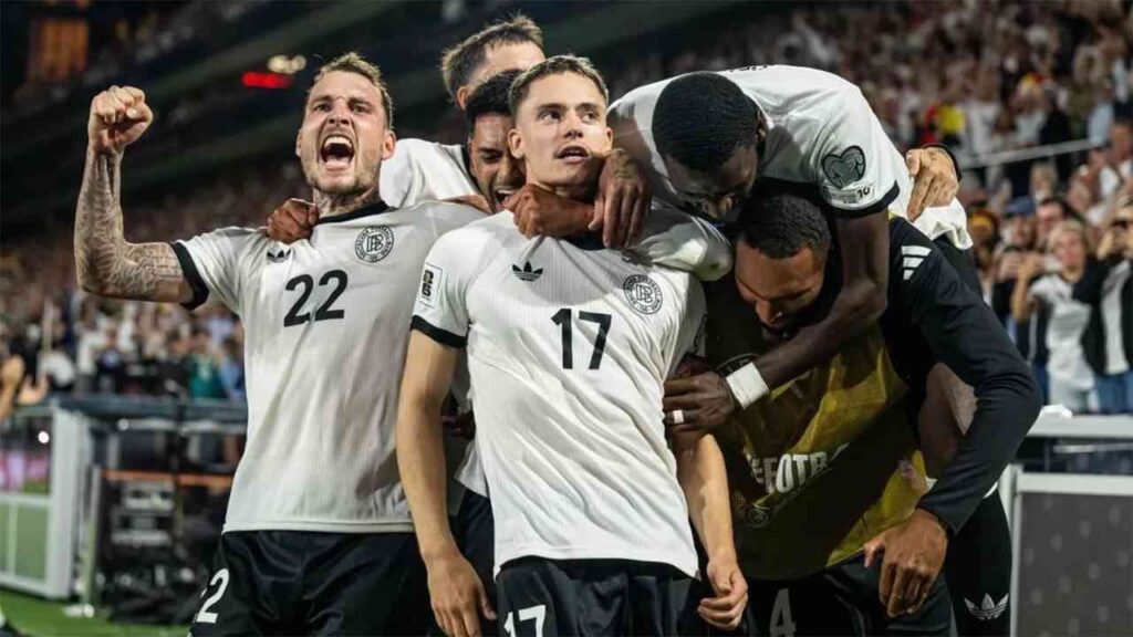 Spieler einer Fußballmannschaft feiern ein Tor während eines Spiels in einem Stadion.