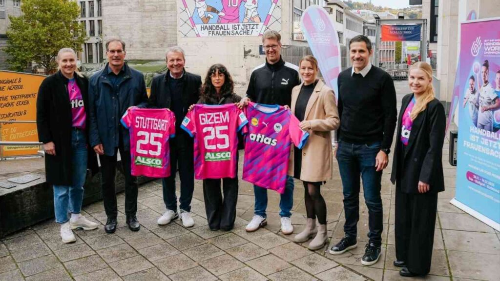 Gruppe von Personen, die pinkfarbene Handballtrikots mit den Namen Stuttgart und Gizem präsentieren.