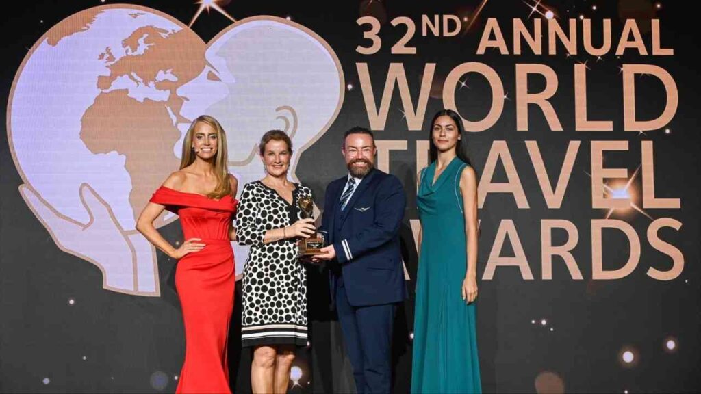 Vier Personen stehen auf einer Bühne bei den 32. jährlichen World Travel Awards und halten eine Auszeichnung.