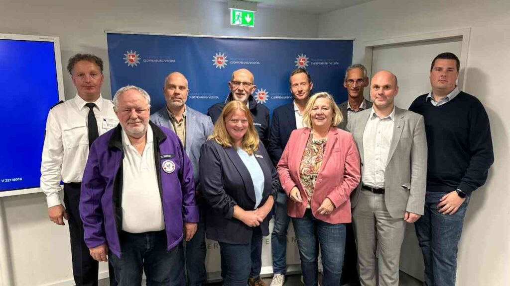 Gruppentreffen mit Vertretern in einem Besprechungsraum, alle in formeller Kleidung.