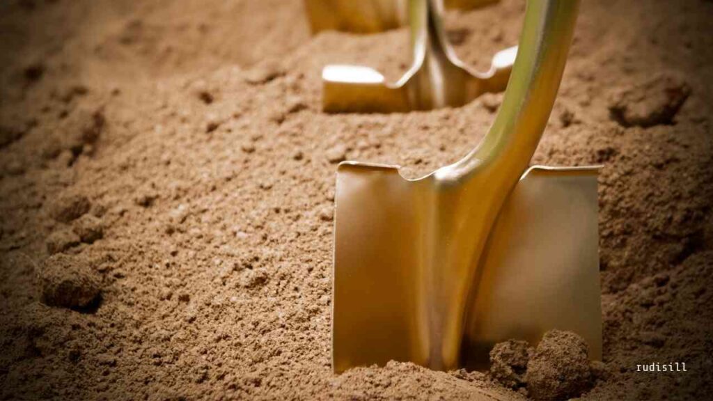 Goldene Schaufeln, die in einem Haufen Erde stecken, symbolisieren den Beginn eines Bauprojekts.