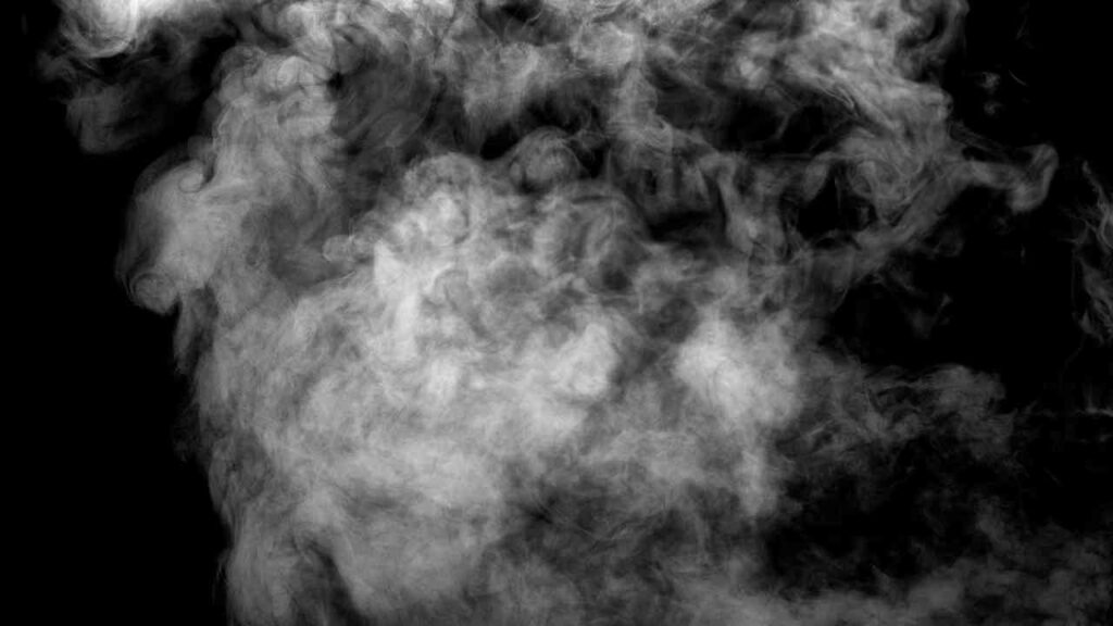 Weißer Rauch, der in einer dunklen Umgebung aufsteigt und sich in verschiedenen Formen verteilt.