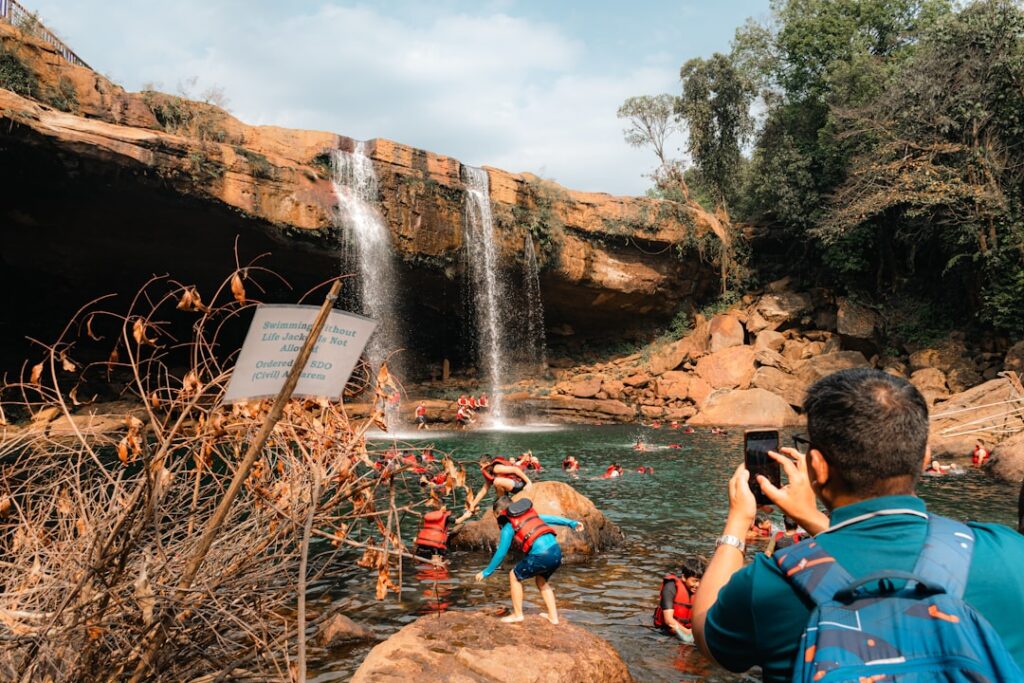 Menschen, die in einem Wasserfall schwimmen und eine natürliche Umgebung genießen.