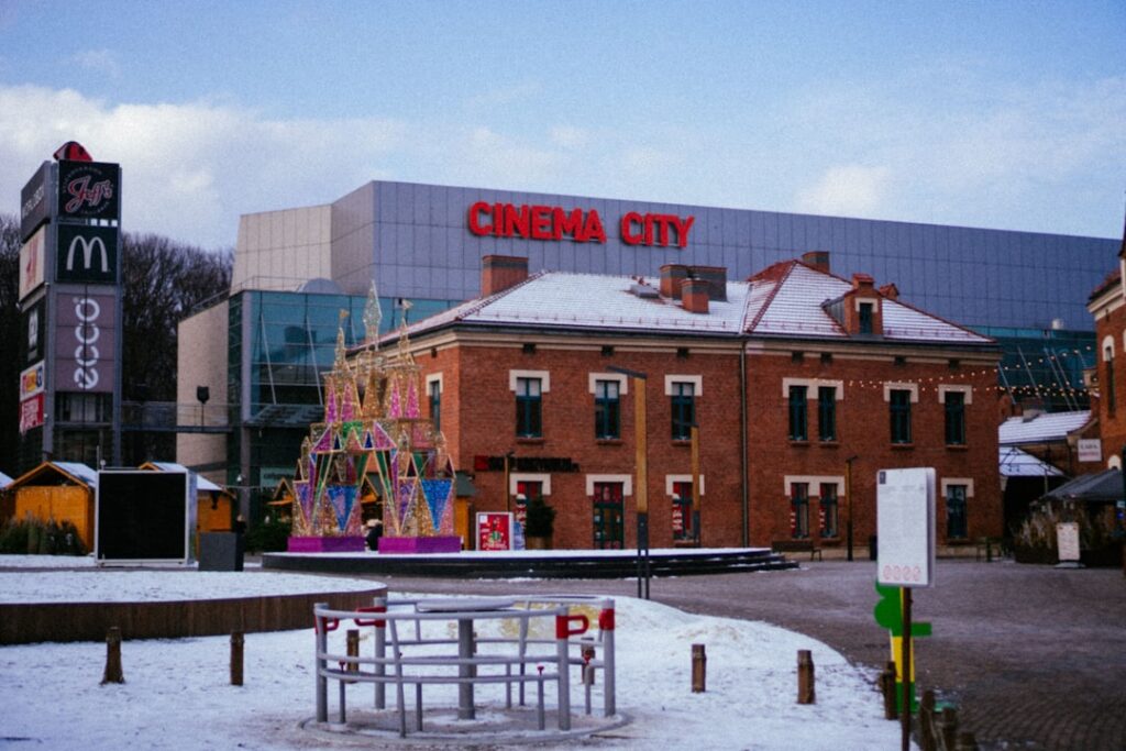 Cinema City mit rotem Schriftzug und angrenzendem historischen Gebäude in einer winterlichen Umgebung.