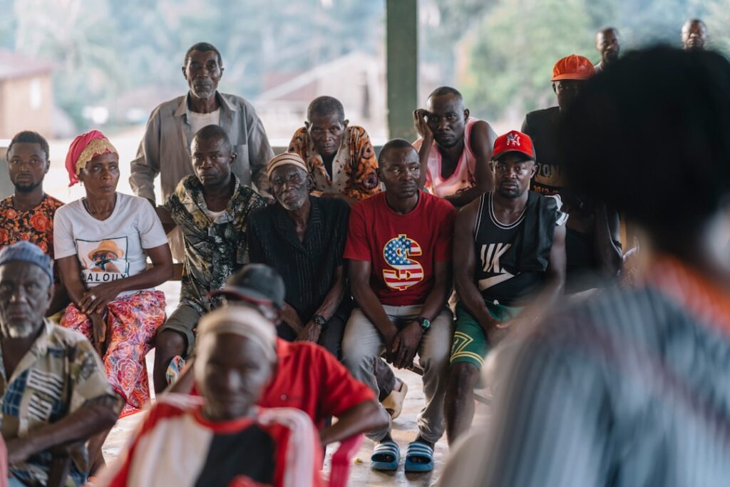 Gruppe von Menschen, die in einem Raum sitzen und einem Vortrag oder einer Präsentation aufmerksam zuhören.