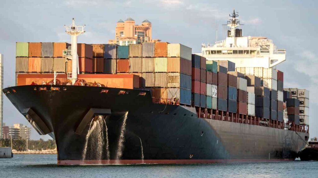 Containerschiff mit zahlreichen Frachtcontainern im Hafen, bereit zur Abfahrt.