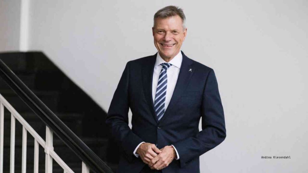 Christoph Tesche, Vorstandsvorsitzender der Stiftung Zollverein, in einem Anzug mit Krawatte vor einer Treppe.