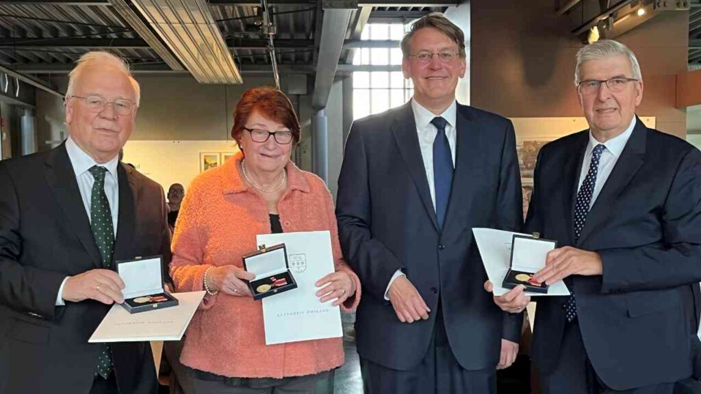 Vier Personen halten Medaillen und Urkunden bei einer Zeremonie zur Verleihung der Emslandmedaille.