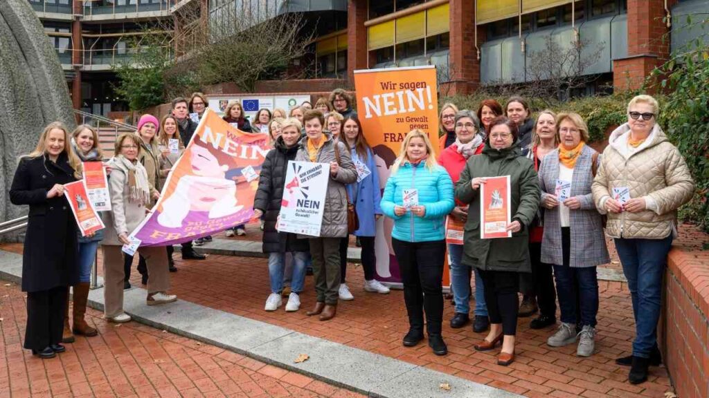 Gruppierung von Frauen, die für den Internationalen Tag gegen geschlechtsspezifische Gewalt demonstrieren, mit Plakaten und Bannern.