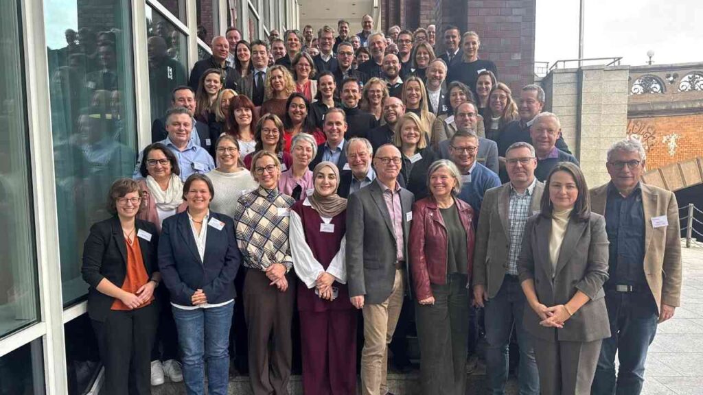 Gruppenfoto von Teilnehmern des PSNV-Symposiums in Hamburg, das eine Vielzahl von Personen zeigt, die zusammenstehen.