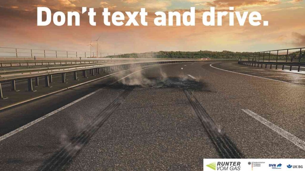 Straße mit Reifenabdrücken und einer Warnung, nicht zu texten und zu fahren.