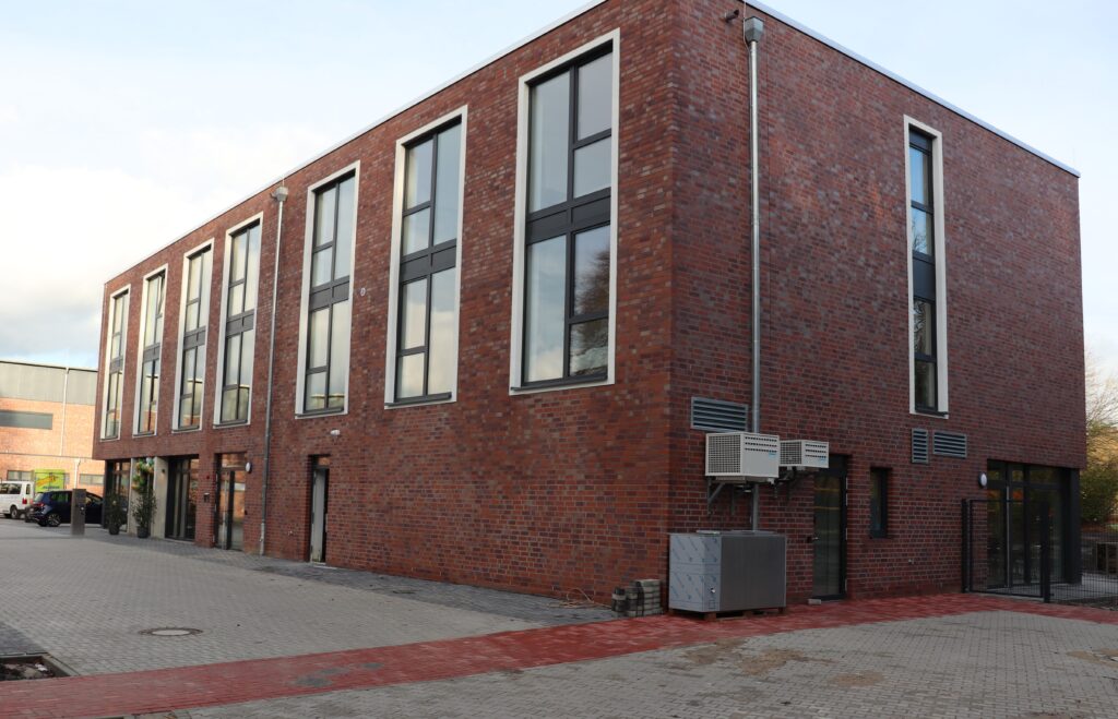 Moderne Backsteinarchitektur eines Gebäudes mit großen Fenstern und einem klaren Design.