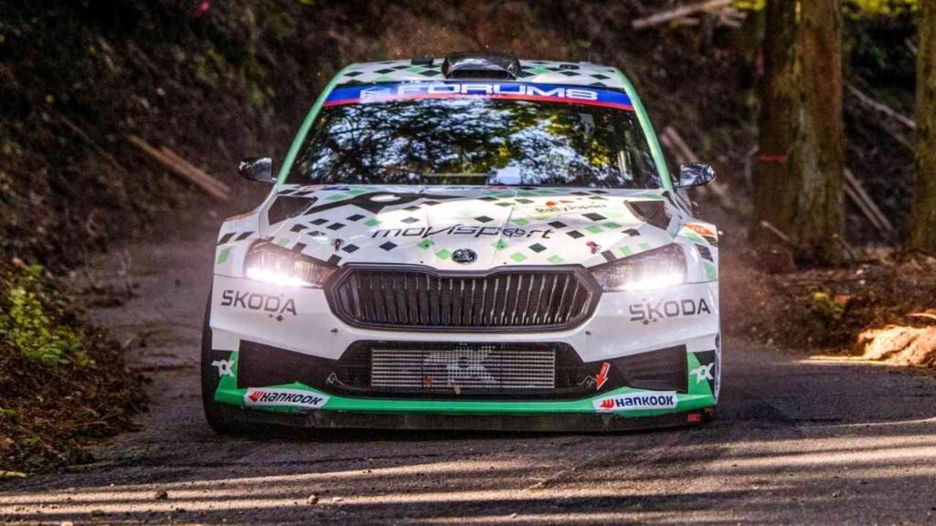 Skoda Fabia RS Rally2 im Rallye-Einsatz auf einer Waldstraße mit grünen und weißen Designelementen.