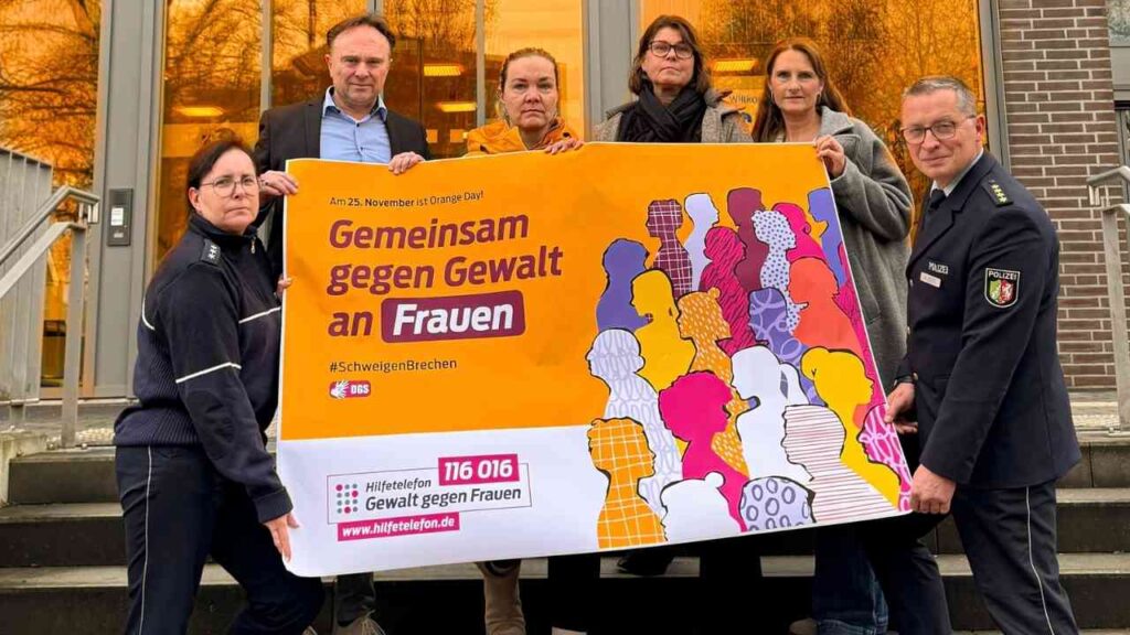 Gruppierung von Personen, die ein Banner mit der Aufschrift 'Gemeinsam gegen Gewalt an Frauen' halten.