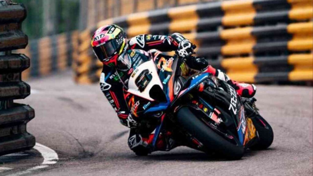 Motorradfahrer auf einer Rennstrecke während des Macau Grand Prix 2025 mit gelben und schwarzen Barrieren.