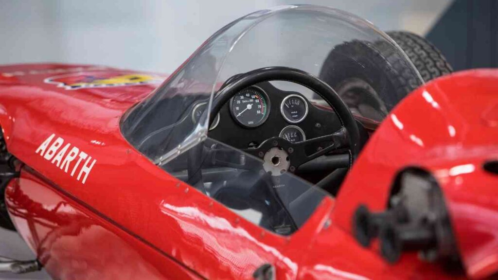 Interieur eines roten Abarth 1000 Chronograph Rennwagens mit Lenkrad und Instrumenten.