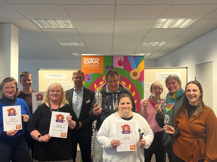 Gruppe von Personen mit Urkunden und Preisen bei einer Veranstaltung der DAK Gesundheit in Bremerhaven.