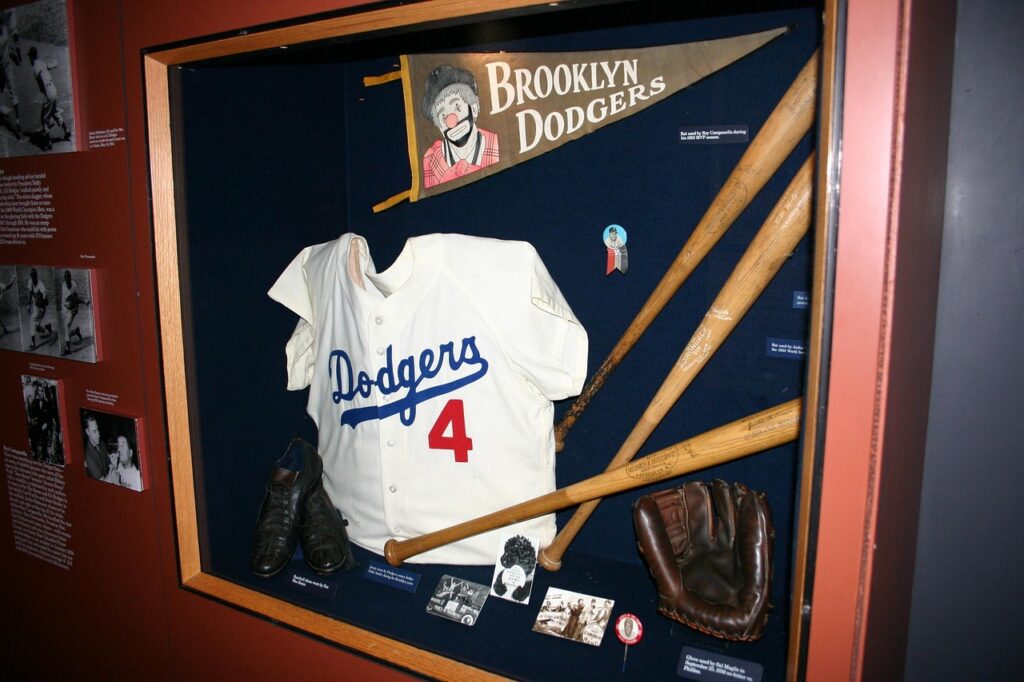 Ein Ausstellungsstück mit einem Brooklyn Dodgers Trikot, Schlägern, Handschuh und weiteren Baseball-Objekten.