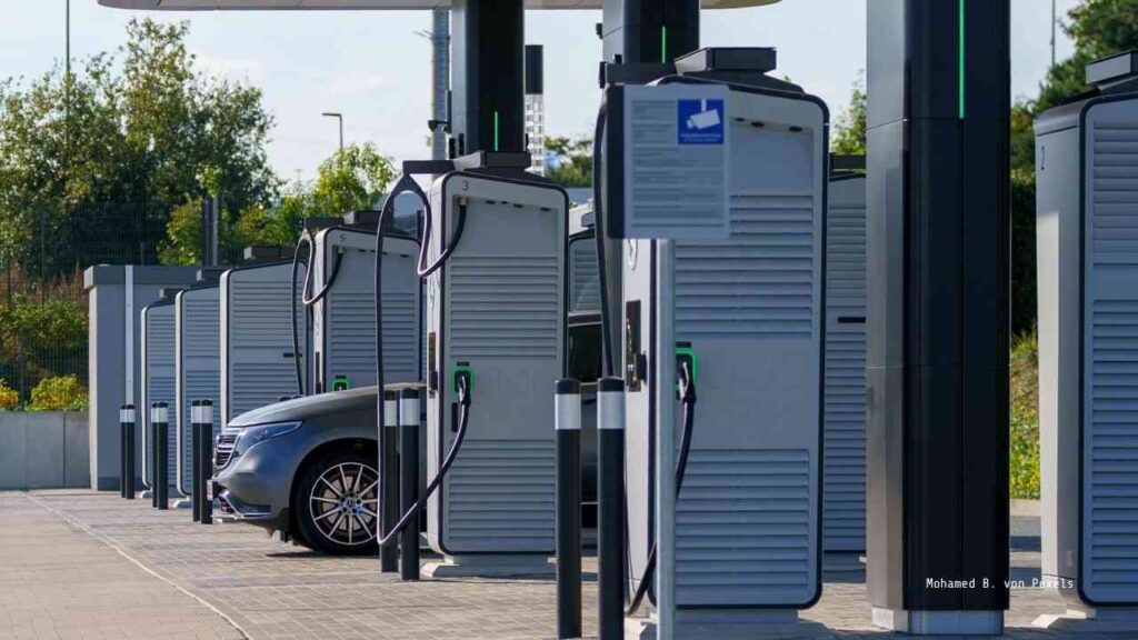 Ladesäulen für Elektrofahrzeuge an einer modernen Ladestation mit einem geparkten Auto.