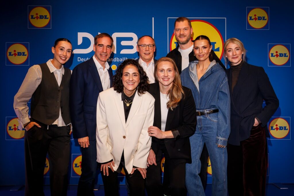 Gruppenfoto von Handballspielern und Offiziellen vor einer blauen Wand mit Logos von DFB und Lidl.