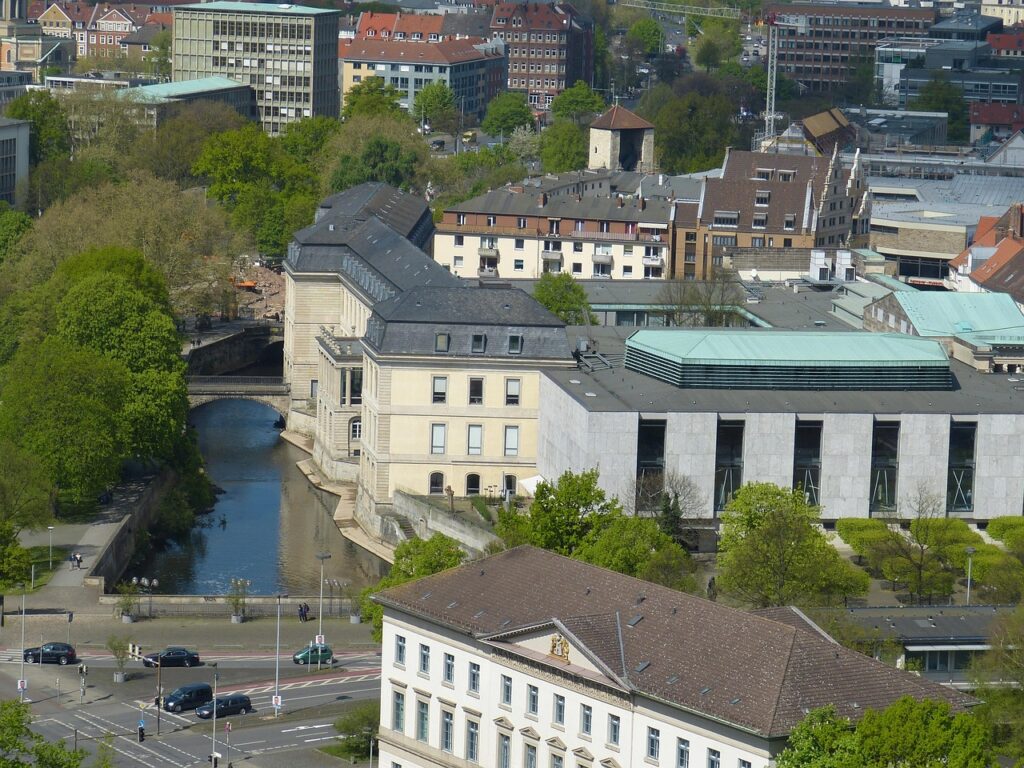 Blick auf ein historisches Gebäude mit moderner Architektur und einem kleinen Fluss in der Nähe in Hannover.