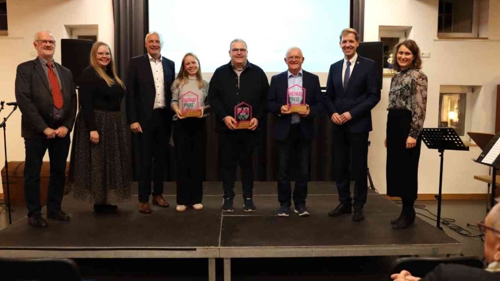 Verleihung des Heimatpreises im Kreis Coesfeld mit mehreren Personen auf der Bühne und Auszeichnungen in den Händen.