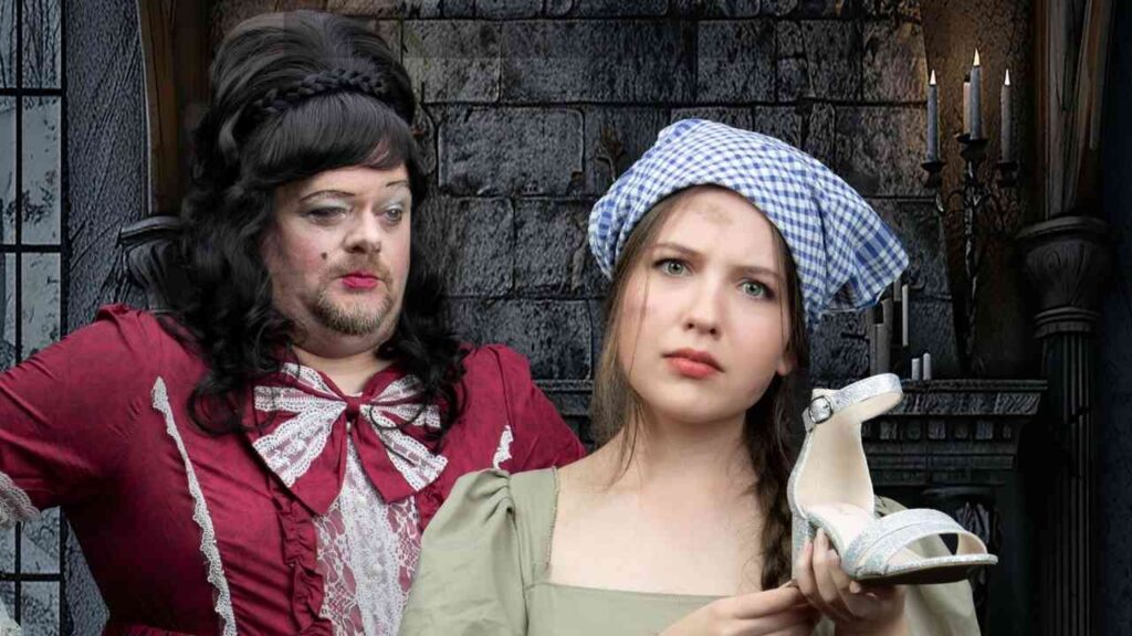 Eine Frau in einem historischen Kleid hält einen Schuh in der Hand, während eine andere Person im Hintergrund schaut.