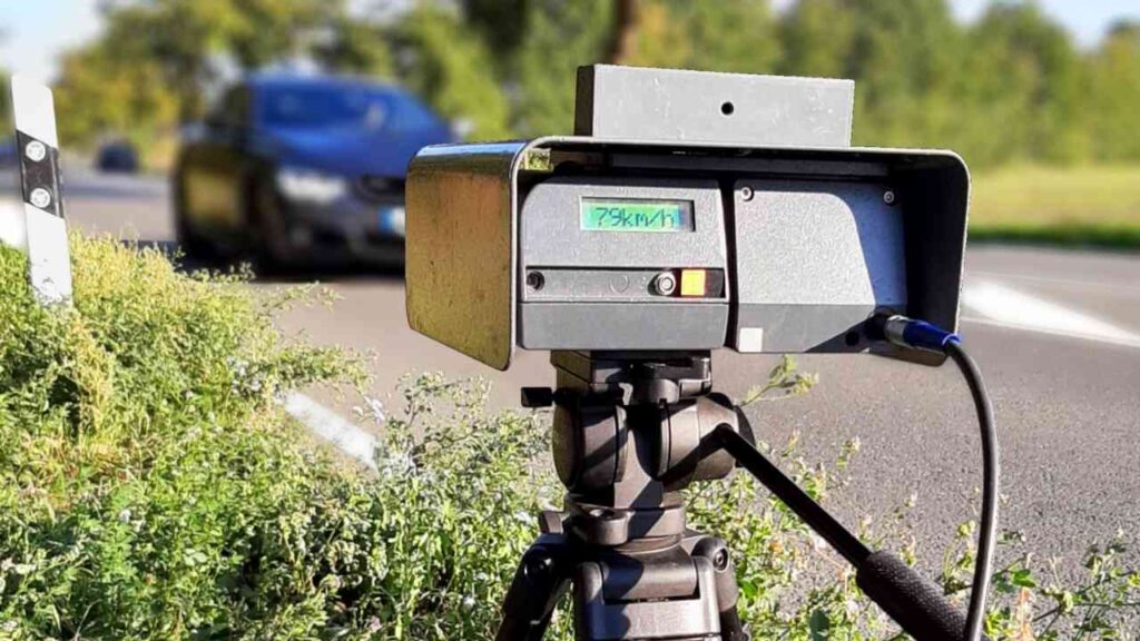 Geschwindigkeitsmessgerät auf einem Stativ an einer Straße zur Überwachung des Verkehrs.