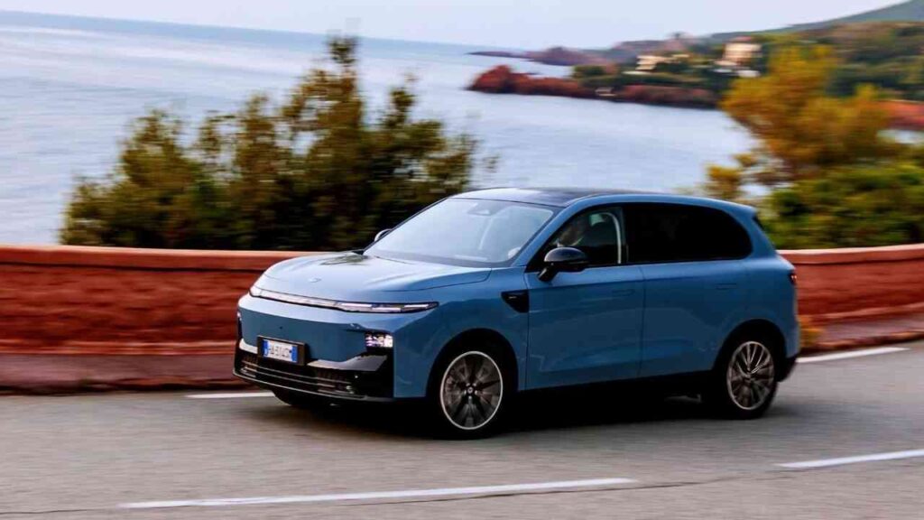 Blauer Elektro-SUV von Leapmotor fährt entlang einer Küstenstraße mit Blick auf das Wasser.