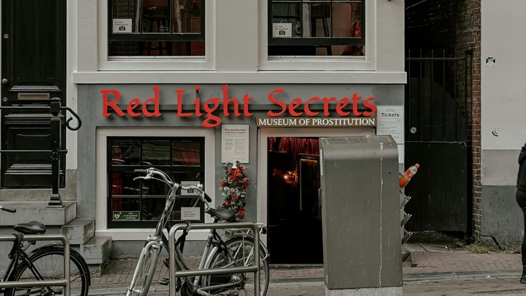 Eingang zum Museum der Prostitution mit rotem Schriftzug 'Red Light Secrets' in Amsterdam.