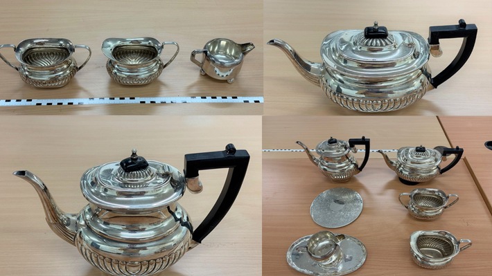 Silbernes Teeservice mit Teekanne, Zuckergefäß und Milchkanne auf einem Tisch.