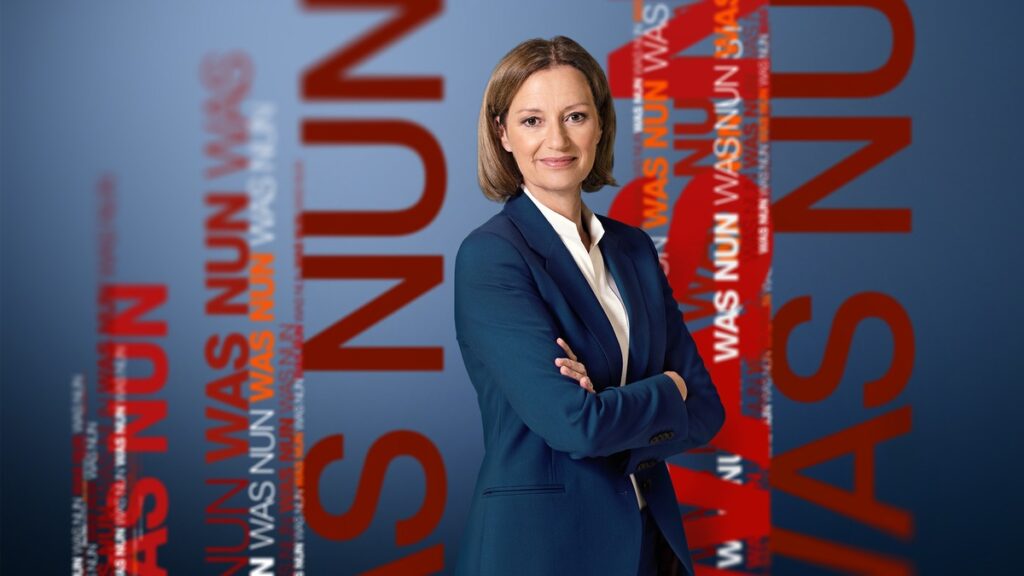 Frau in blauer Blazerjacke mit verschränkten Armen vor einem grafischen Hintergrund mit Text in Rot und Blau.