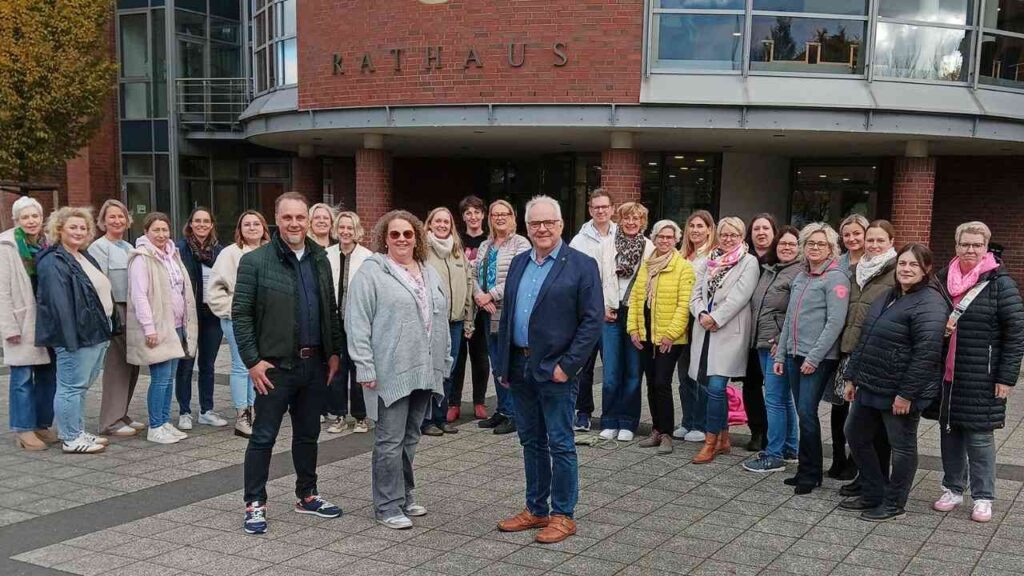 Gruppe von Menschen vor dem Rathaus in Cloppenburg, die an einer Schulstart-Kooperation teilnehmen.