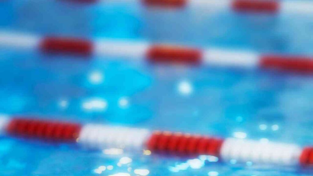 Schwimmbecken mit roten und weißen Bahnmarkierungen auf der Wasseroberfläche.