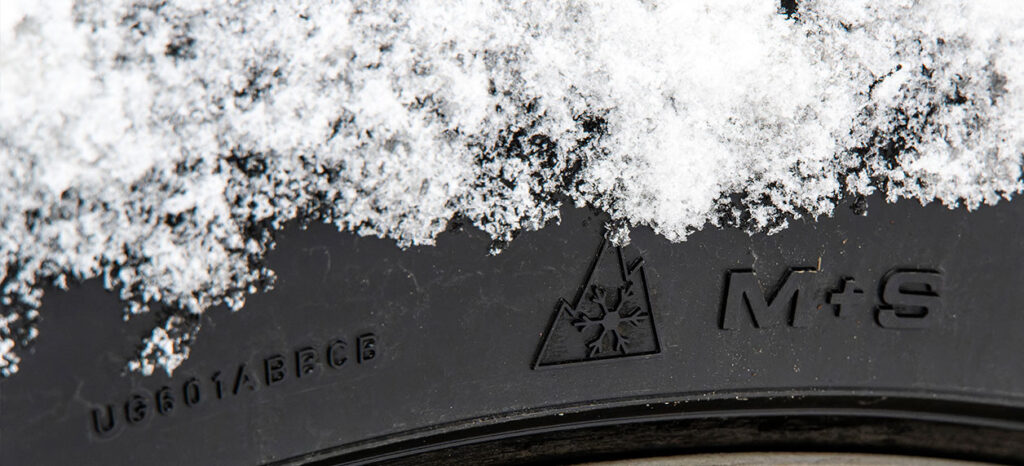 Winterreifen mit M+S Kennzeichnung und Schnee auf der Oberfläche, geeignet für winterliche Fahrbedingungen.