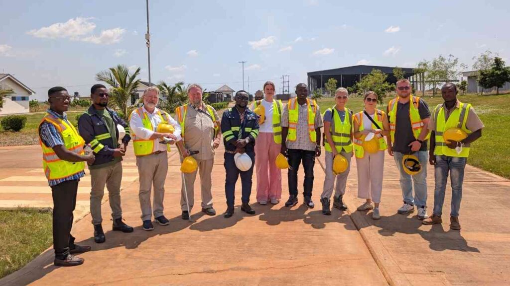 Gruppe von Fachleuten in Sicherheitswesten und Helmen auf einer Baustelle in Wamale, Ghana.