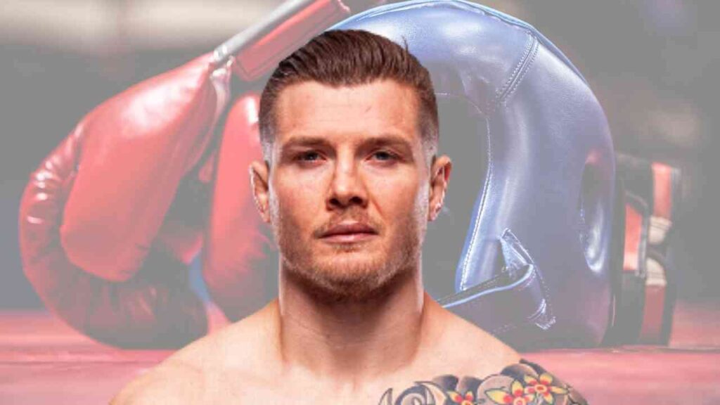 Marvin Vettori, ein MMA-Kämpfer mit Tätowierungen, vor Boxhandschuhen und einem Boxhelm.