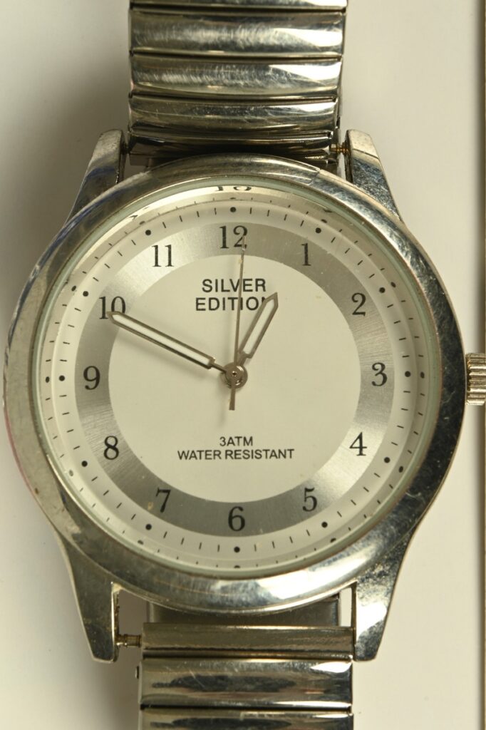 Silberne Armbanduhr mit einem weißen Zifferblatt und einem Metallarmband, das die Aufschrift 'Silver Edition' trägt.