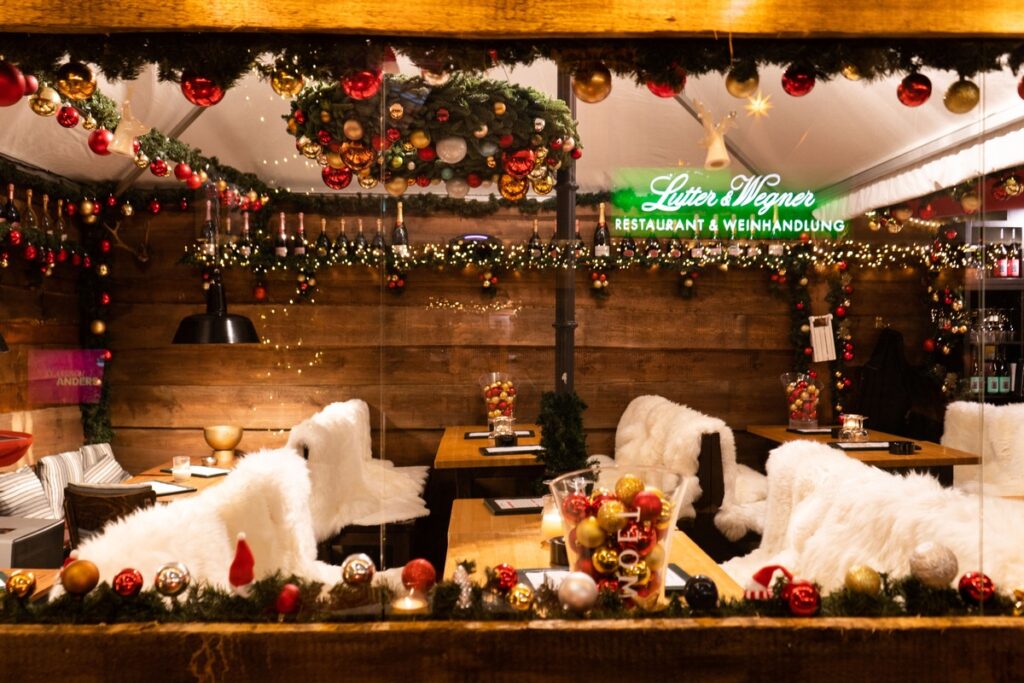 Gemütlicher Innenraum eines Restaurants mit festlicher Weihnachtsdekoration und Tischen.