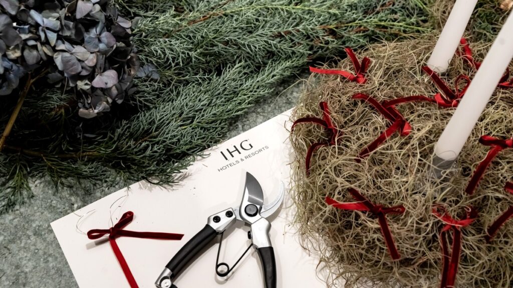 Gartenschneider und dekorative Materialien auf einem Tisch mit IHG Hotels & Resorts Logo.