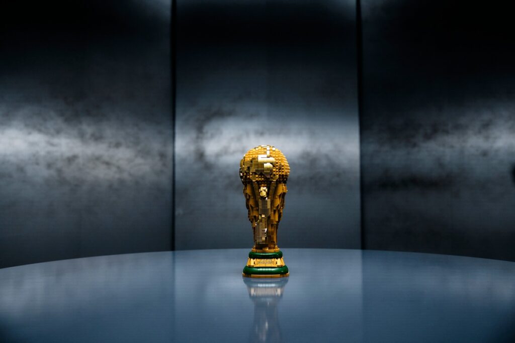 Lego-Nachbildung des FIFA-Weltmeisterschaftspokals auf einem Tisch in einem minimalistischen Raum.