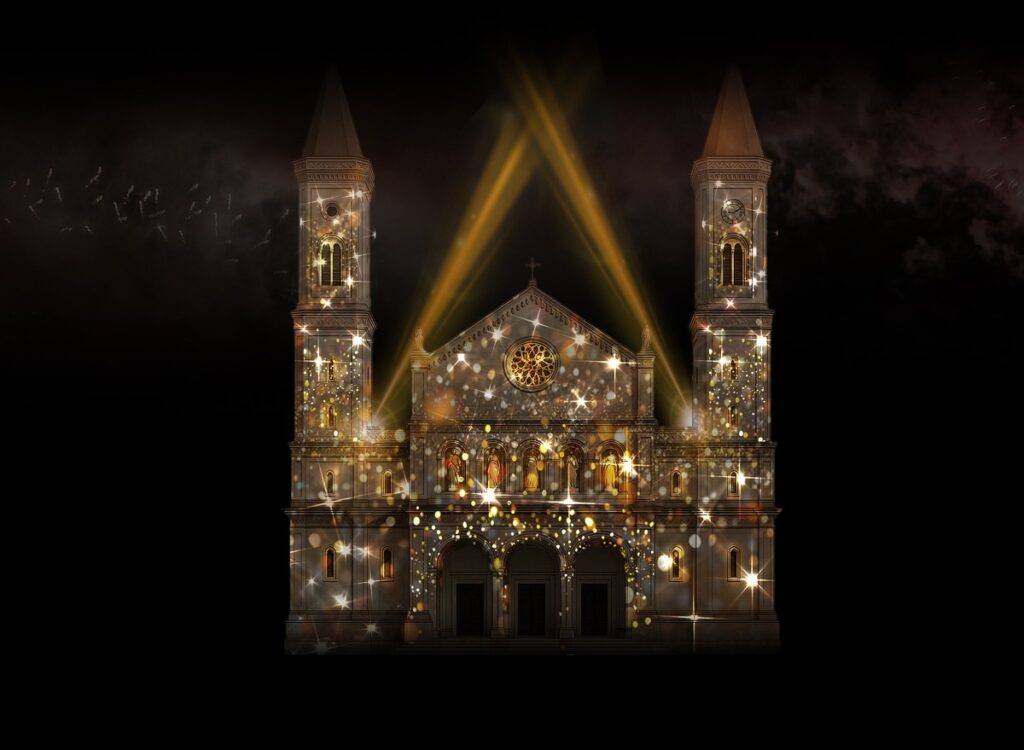 Illuminierte Kirche mit Lichtern und Scheinwerfern, die eine festliche Atmosphäre erzeugen.