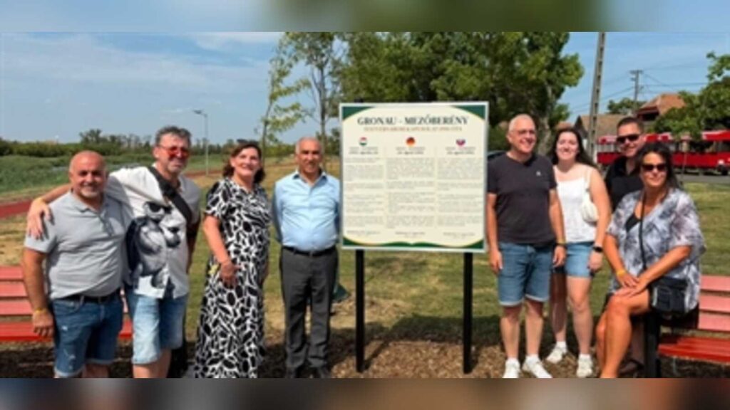 Gruppe vor der Tafel des Freundschaftsparks mit der Aufschrift Gronau – Mezőberény