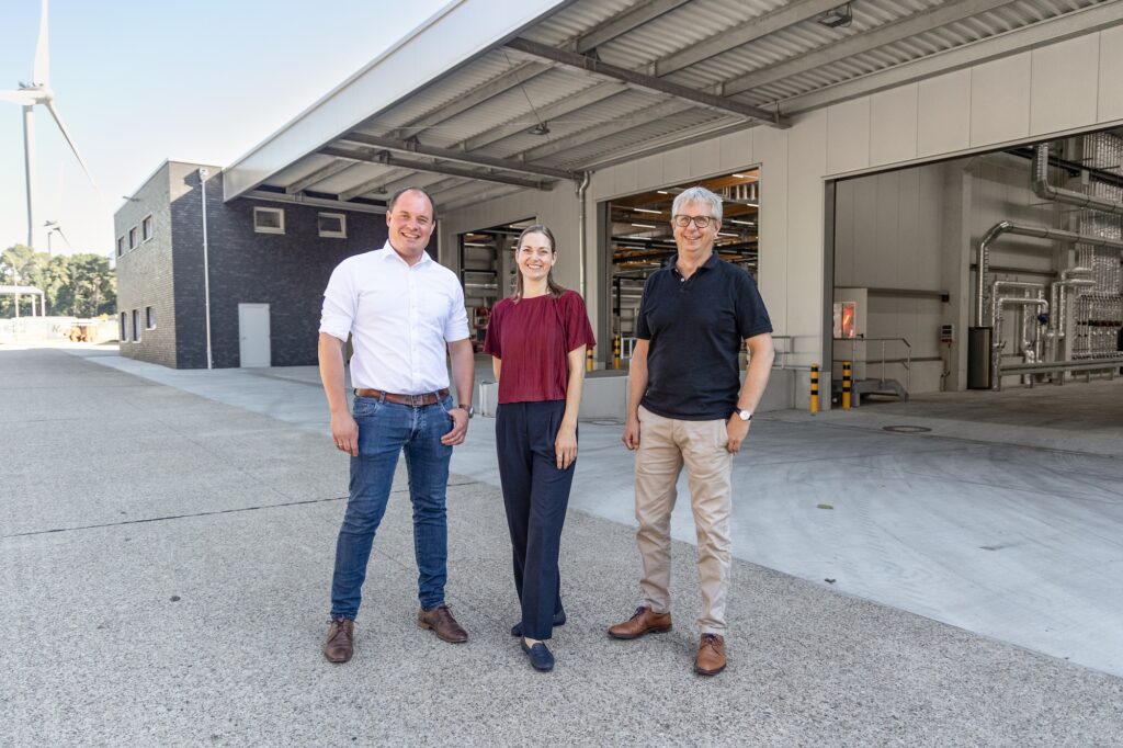 Robin Krampe, Eliza Diekmann-Cloppenburg und Philipp Hänsel vor der neuen Fertigungshalle von Krampe Fahrzeugbau