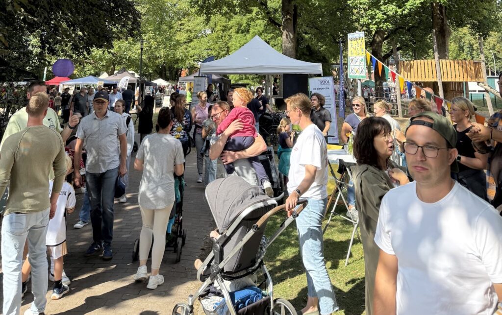 Besucherinnen und Besucher schlendern beim Sommerfest im Stadtpark Gescher zwischen Ständen