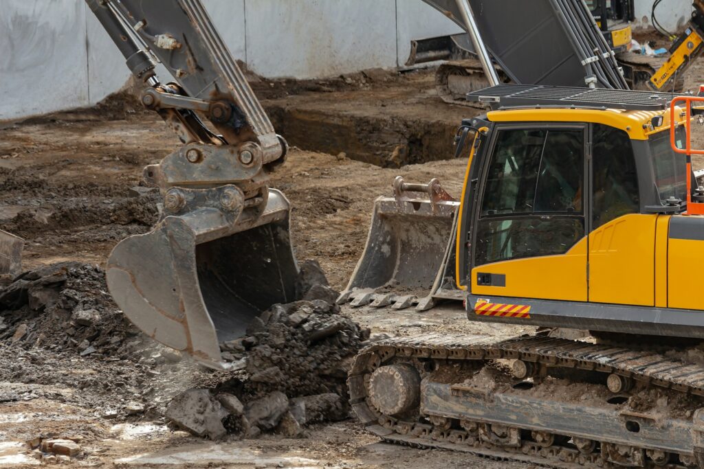 Bagger hebt belasteten Boden auf einer Baustelle aus - Symbolbild fuer die Bodensanierung an der Feuerwache Nord in Nordhorn