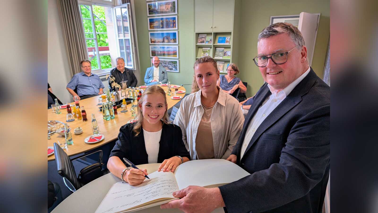 Lena Börner trägt sich gemeinsam mit ihrer Trainerin Rebecca Haase ins Goldene Buch der Stadt Nordhorn ein