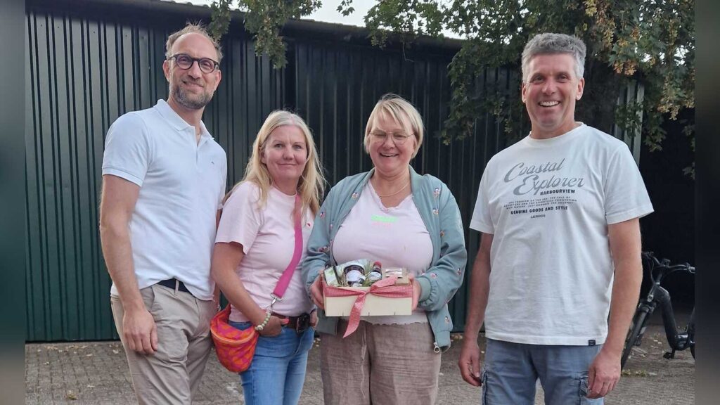 Vier Personen stehen auf einem landwirtschaftlichen Hof in Holthausen-Biene