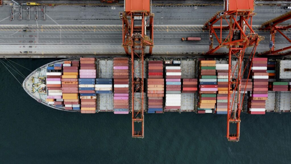 Luftaufnahme eines Containerschiffs, das im Hafen entladen wird