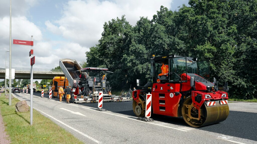 Asphaltfertiger und Straßenwalze bei der Erneuerung eines Fahrbahnbelags